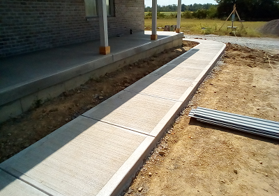 Concrete pathway beside brick house