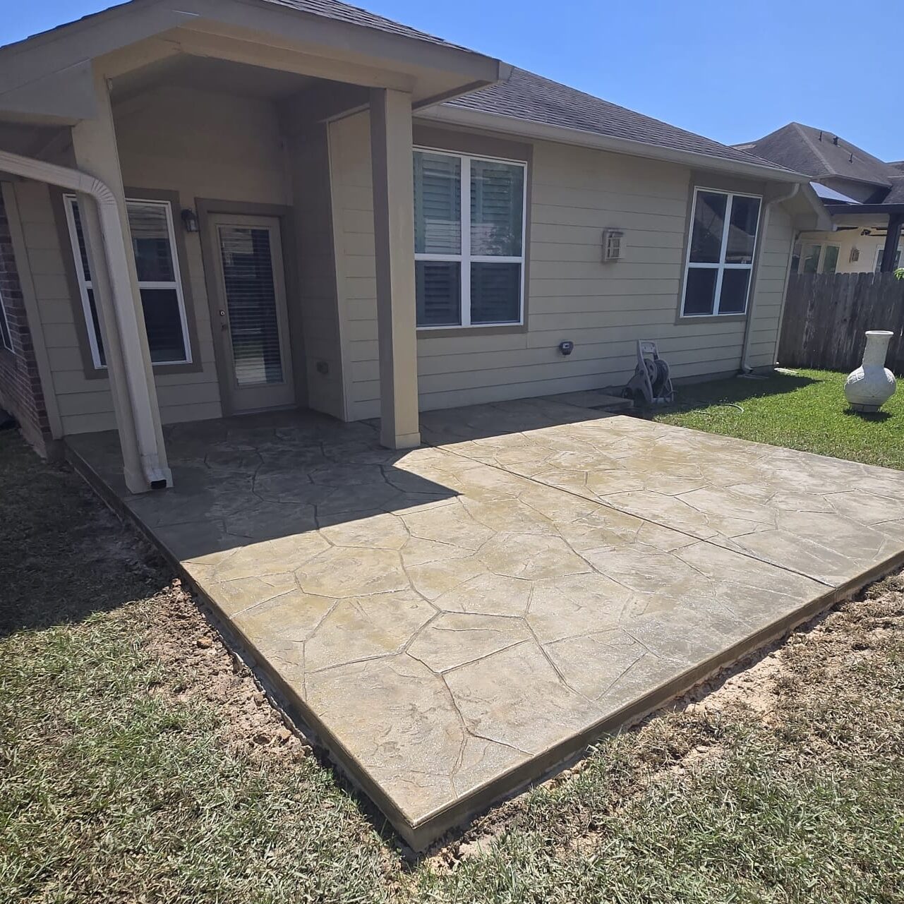 Sunny backyard featuring a new patio