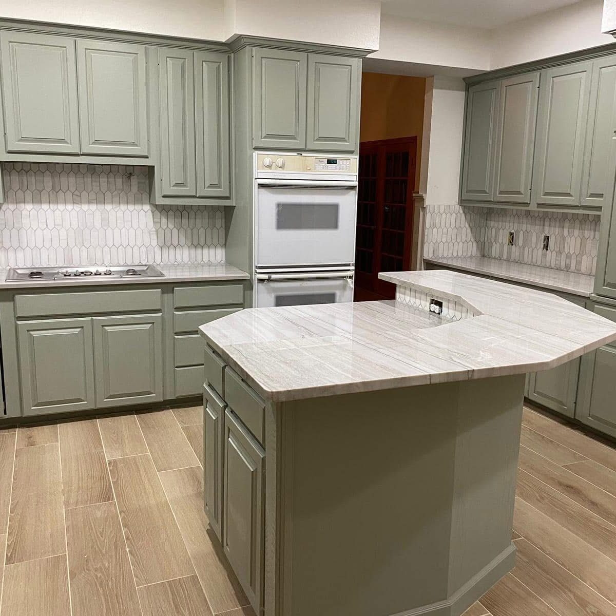 Modern kitchen with green cabinets and island
